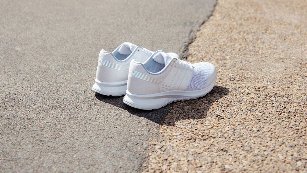 Chaussures de running neutres posées entre route et chemin stabilisé
