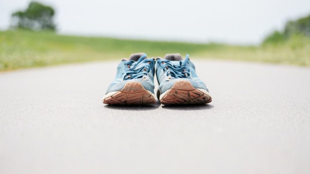 Chaussures de running sobres et usées posées sur un chemin sans logo ni texte
