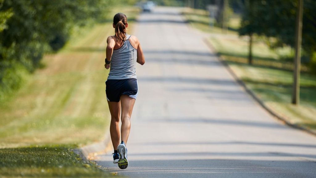 Coureur amateur sur une montée douce bordée d’arbres en Alsace