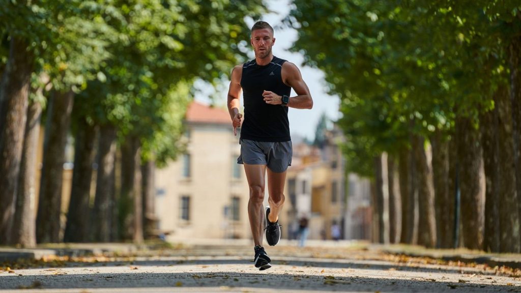 Coureur amateur sur chemin calme regardant sa montre sans marque visible