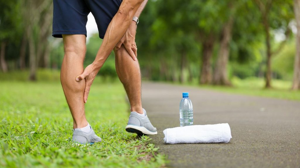 Coureuse faisant un étirement doux des mollets après un footing dans un parc
